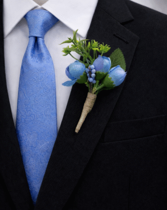 blue floral boutonniere on black suit lapel wedding groom accessory”