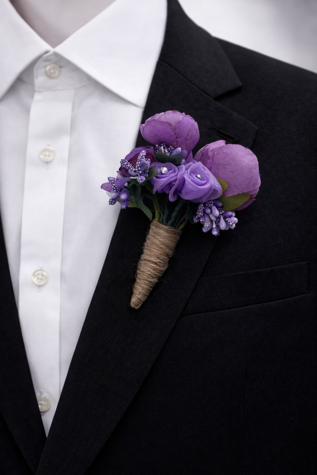 deep purple boutonniere with matching paisley tie on black suit groom wedding accessory set