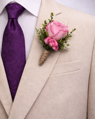 pink rose boutonniere with purple tie on beige suit groom wedding accessory set